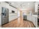 Bright kitchen featuring stainless steel appliances, white cabinetry, hardwood flooring, and natural light at 2050 Woodberry Run Dr, Snellville, GA 30078