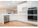 Modern kitchen with white cabinetry, stainless steel appliances, a double oven, and hardwood flooring at 2050 Woodberry Run Dr, Snellville, GA 30078