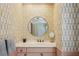 Powder room with patterned wallpaper, a round mirror, and a pink vanity at 3086 E Pine Valley Nw Rd, Atlanta, GA 30305