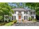 Elegant white brick home features black shutters, a copper roof, and manicured landscaping at 3086 E Pine Valley Nw Rd, Atlanta, GA 30305