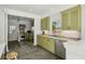 Charming kitchen features sage colored cabinets, stone tile floor, and modern stainless steel appliances at 3086 E Pine Valley Nw Rd, Atlanta, GA 30305