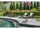 Swimming pool with lounge chairs, dining set, and lush landscaping at 3086 E Pine Valley Nw Rd, Atlanta, GA 30305