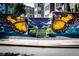 Colorful butterfly wing mural with a yellow bench, set against a modern apartment building at 480 John Wesley Dobbs Ne Ave # 418, Atlanta, GA 30312