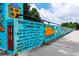 A vibrant community mural painted by local children on a retaining wall in a neighborhood park at 480 John Wesley Dobbs Ne Ave # 418, Atlanta, GA 30312
