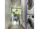 Hallway view shows stackable laundry, concrete walls, and view of dining space overlooking greenery at 480 John Wesley Dobbs Ne Ave # 418, Atlanta, GA 30312