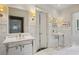 Dual-sink bathroom with marble countertops, wainscotting, and a doorway to another room at 603 E Paces Ferry Ne Rd, Atlanta, GA 30305