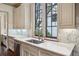 This kitchen features marble countertops, modern cabinetry, and stainless steel appliances near a window overlooking the outdoors at 603 E Paces Ferry Ne Rd, Atlanta, GA 30305