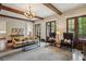 Relaxing living room with beamed ceilings, fireplace and hearth, and french doors overlooking mature landscaping at 603 E Paces Ferry Ne Rd, Atlanta, GA 30305