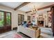 Cozy living room with fireplace, built-in shelving, wood beams, and french doors to the backyard at 603 E Paces Ferry Ne Rd, Atlanta, GA 30305