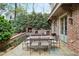 Charming outdoor patio with a stone fireplace, a dining table, and lush greenery for relaxing or entertaining at 603 E Paces Ferry Ne Rd, Atlanta, GA 30305