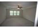 Spacious primary bedroom with a ceiling fan, tray ceiling and large windows at 6348 Lanier Harbor Lndg, Buford, GA 30518