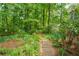 Stone path through a lush backyard garden surrounded by mature trees and greenery at 258 Lancaster Cir, Marietta, GA 30066
