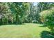 Well-maintained backyard featuring lush greenery and mature trees at 2903 Southpark Sw Ter, Conyers, GA 30094