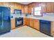 Well-lit kitchen featuring wooden cabinetry, black appliances, and white countertops at 2903 Southpark Sw Ter, Conyers, GA 30094