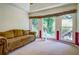 Bright living room featuring a comfortable sofa and large windows offering lush greenery views at 2903 Southpark Sw Ter, Conyers, GA 30094