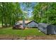 Beautiful backyard featuring a wooden deck, lush greenery, a storage shed, and mature trees at 76 Hollis Cir, Dallas, GA 30157