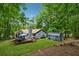Large backyard with a well-maintained lawn, a spacious deck, and a charming shed surrounded by lush trees at 76 Hollis Cir, Dallas, GA 30157
