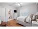 Cozy bedroom with hardwood floors, white bedding, and a view into an ensuite bathroom at 105 Thorncliff Way, Acworth, GA 30101