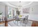 Bright dining room showcasing elegant chandelier, tray ceiling, and large window at 105 Thorncliff Way, Acworth, GA 30101