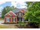 Beautiful brick home featuring black shutters, columns, mature trees and manicured landscaping at 105 Thorncliff Way, Acworth, GA 30101