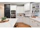 Modern kitchen featuring white cabinets, stainless steel appliances, a chalkboard wall, and wood floors at 105 Thorncliff Way, Acworth, GA 30101