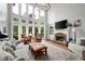 Sunlit living room with stone fireplace, two-story windows, and comfortable seating for relaxing or entertaining guests at 105 Thorncliff Way, Acworth, GA 30101