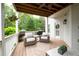 Relaxing back porch area complete with seating, ceiling fan, and wooded scenery at 105 Thorncliff Way, Acworth, GA 30101