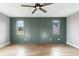 A stylish bedroom with an accent wall, hardwood floors, ceiling fan, and large bright windows at 170 Paislee Park (Lot #8 Paislee Park) Dr, Fayetteville, GA 30215
