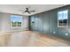 A large bedroom with gray paneled accent wall, hardwood flooring, and bright windows at 170 Paislee Park (Lot #8 Paislee Park) Dr, Fayetteville, GA 30215