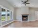 Comfortable living space featuring a ceiling fan, a cozy fireplace with wood mantle, and large windows for ample natural light at 170 Paislee Park (Lot #8 Paislee Park) Dr, Fayetteville, GA 30215