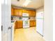 Clean kitchen with oak cabinets, white appliances, and a tiled floor for easy maintenance at 176 Darbys Crossing Ct, Hiram, GA 30141