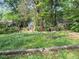 Spacious backyard with lush ground cover, mature trees and multiple outbuildings at 1941 Headland Dr, East Point, GA 30344