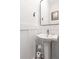 Clean half bath with pedestal sink, decorative mirror, and wainscoting provides style and functionality at 1265 Wright Se Ln, Atlanta, GA 30316