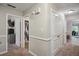 Hallway featuring carpet, multiple doors, gray walls, and views into connecting rooms with a TV at 161 Brookfield Dr, Stockbridge, GA 30281