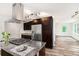 Modern kitchen with stainless steel appliances, granite countertops, and an island cooktop with dark wood cabinets at 2674 Skylane Dr, Marietta, GA 30062