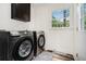 Laundry room with modern washer and dryer, upper cabinet, and a view to the backyard at 2674 Skylane Dr, Marietta, GA 30062
