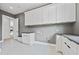 Laundry room boasts white cabinets, dark countertops, and modern design features at 292 Highway 279, Fayetteville, GA 30214