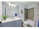 Bright bathroom with tiled shower, blue vanity, and modern fixtures at 976 Arthur Nw Ln, Atlanta, GA 30318