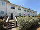 The rear of the house shows the back doors and wooden deck area with shrubs around the home at 229 Odyssey Turn, Conyers, GA 30012