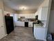Functional kitchen featuring white cabinetry, black appliances, and vinyl plank flooring at 229 Odyssey Turn, Conyers, GA 30012