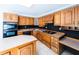 Eat-in kitchen with center island, wood cabinets, built-in range, and black backsplash at 5479 Dorsett Shoals Rd, Douglasville, GA 30135