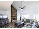 Bright living room featuring a stone fireplace, ceiling fan, and large sectional sofa at 5479 Dorsett Shoals Rd, Douglasville, GA 30135