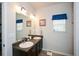 Bathroom featuring a double sink vanity with a window and decorative mirror with vanity lighting at 692 Oakside Pl, Acworth, GA 30102