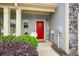 Inviting front porch featuring a red door with wreath and colorful landscaping at 692 Oakside Pl, Acworth, GA 30102