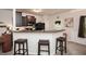Open kitchen with breakfast bar and sleek black appliances that seamlessly flows into the living space at 692 Oakside Pl, Acworth, GA 30102