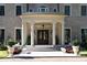 Impressive front entrance features grand columns, a covered porch, double doors, and meticulously manicured landscaping at 1040 W Conway Nw Dr, Atlanta, GA 30327