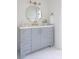 Bright bathroom featuring a round mirror, gray vanity, white countertop, and gold hardware at 4085 Chadds Walk, Marietta, GA 30062