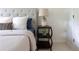 Close-up of a nightstand with an attractive lamp and a flower vase next to a bed with a cushioned headboard at 4085 Chadds Walk, Marietta, GA 30062