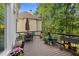 Relaxing back deck with black metal furniture and many colorful potted plants surrounded by green foliage at 4731 Moon Chase Dr, Buford, GA 30519