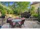 Seating area in backyard with stone patio, koi pond, and mature landscaping at 4731 Moon Chase Dr, Buford, GA 30519